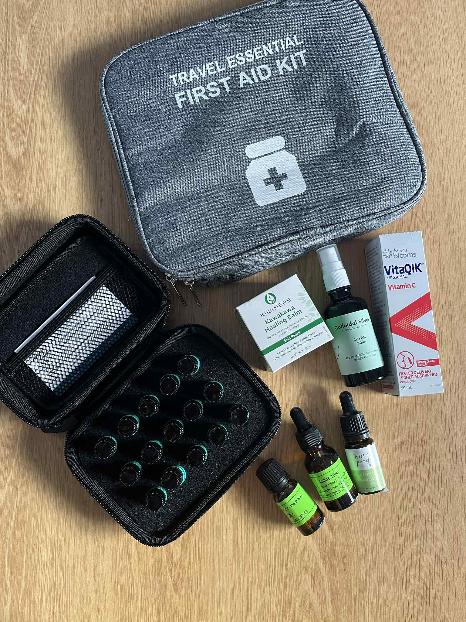 Travel essential naturopathic and homeopathic naturl first aid medicine kit flat laid on wooden table. 