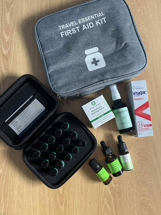 Travel essential naturopathic and homeopathic naturl first aid medicine kit flat laid on wooden table. 